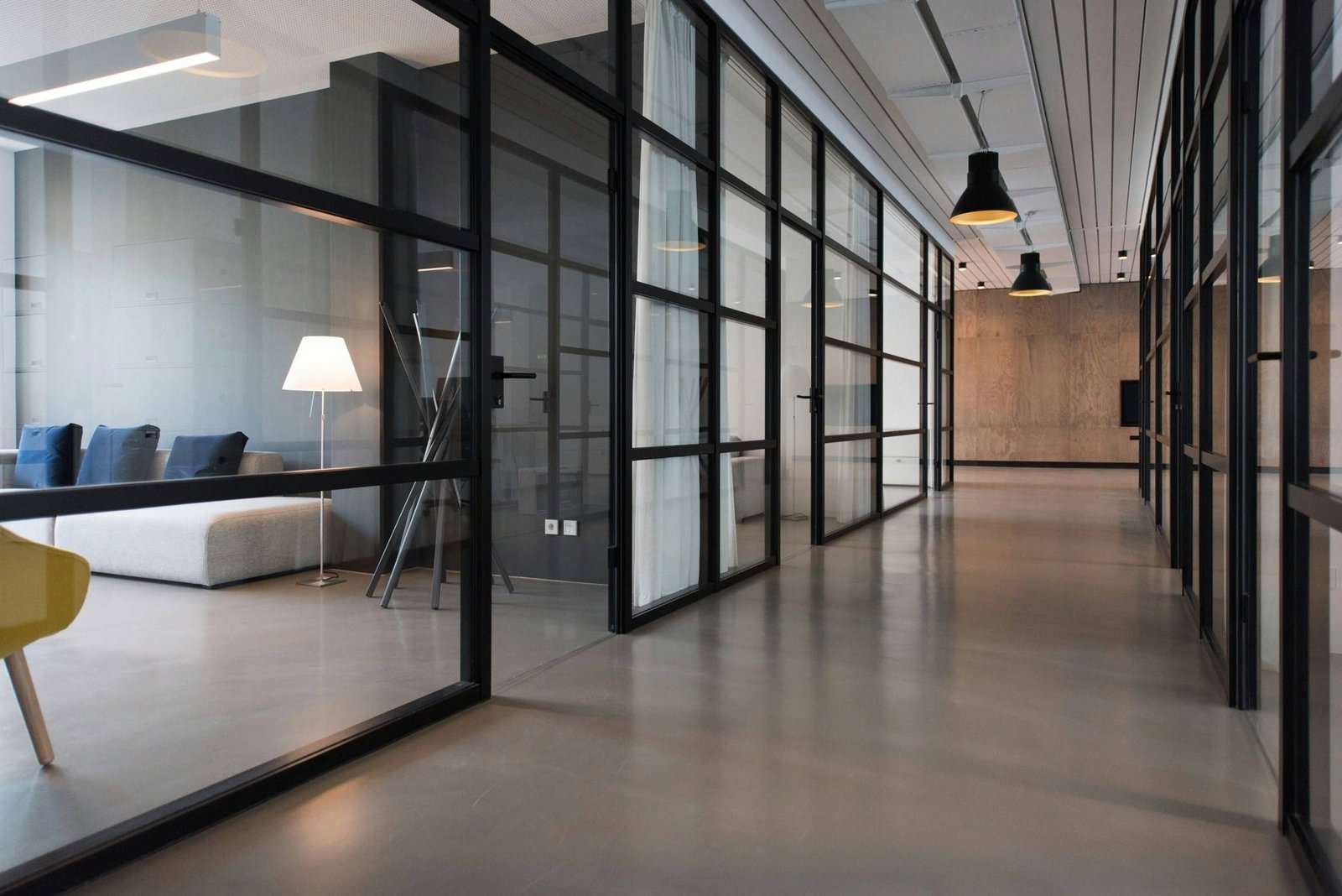 Siyah profilli cam bölmelerle ofis koridoru